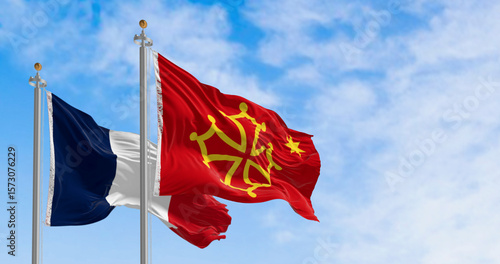 Flags of Occitanie region and France waving in the wind on a clear day