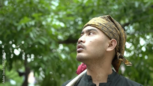 Thoughtful Man in Traditional Headscarf Surrounded by Nature