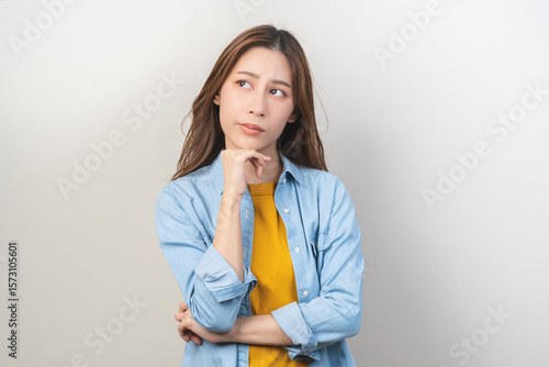 Photography Thinking with problem, frustrated asian young woman, girl expression face thoughtful, brunette hair wearing casual t-shirt, gesture strain emotion, looking away standing isolated on white background
