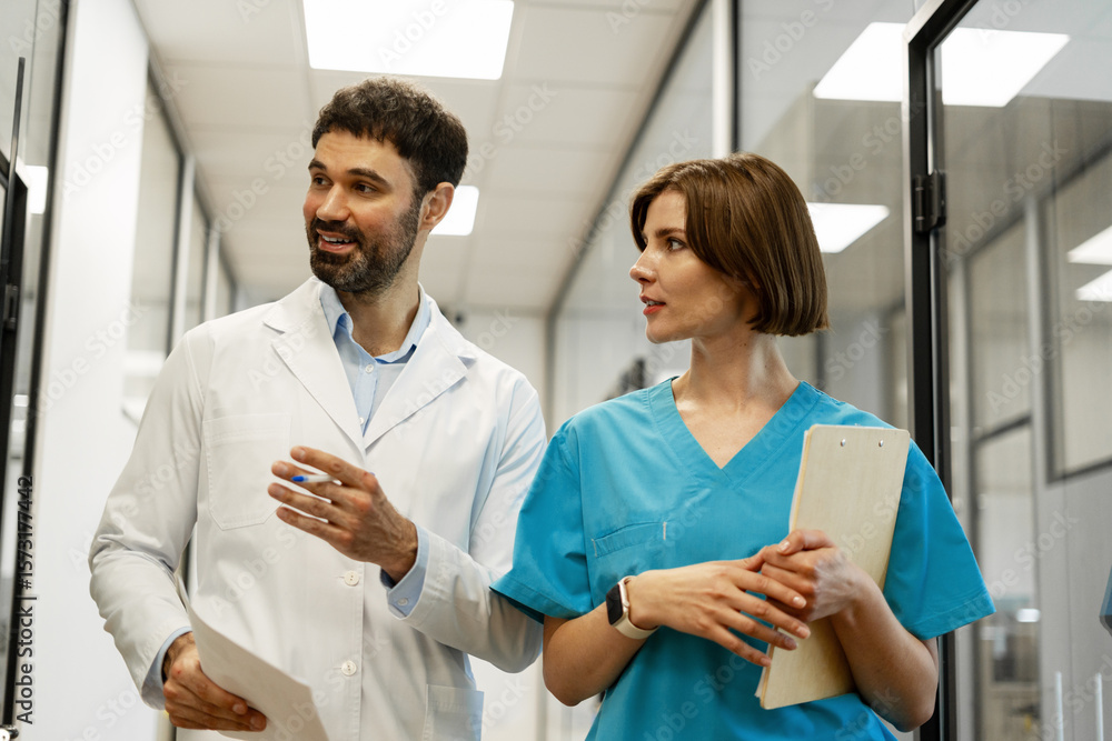 Obraz premium Doctors discussing diagnosis while walking in hospital corridor