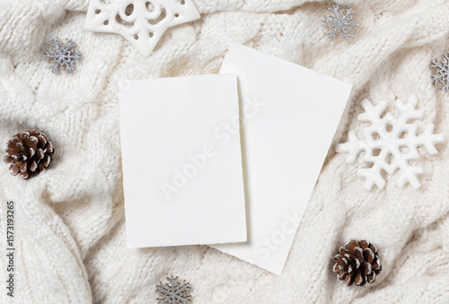 Vertical blank cards on white knitted sweater near Christmas decor, winter Holiday mockup