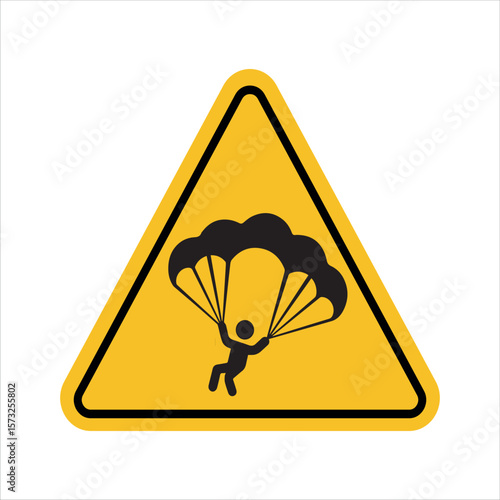 Yellow triangular warning sign with parachute symbol indicating skydiving safety hazard for aerial sport