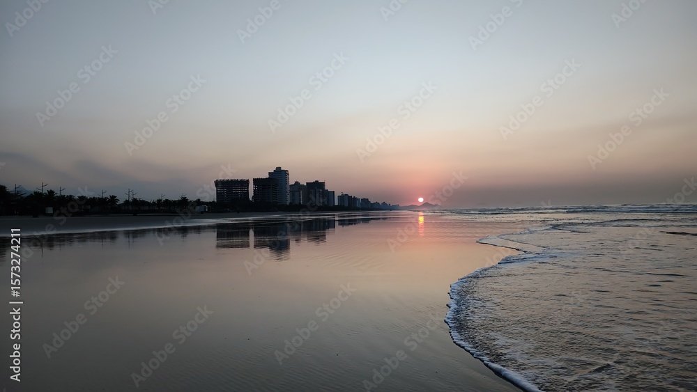Nascer do sol dourado na Praia Grande, SP. Silhuetas urbanas refletidas na orla calma sob luz matinal. Ideal para temas de viagem e natureza urbana. Nascer do sol dourado na Praia Grande, SP. Silhuetas urbanas refletidas na orla calma sob luz matinal. Ideal para temas de viagem e natureza urbana.