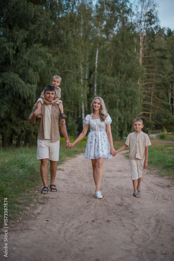 Happy young family walking down the road outside in green nature. Happy young family walking down the road outside in green nature.