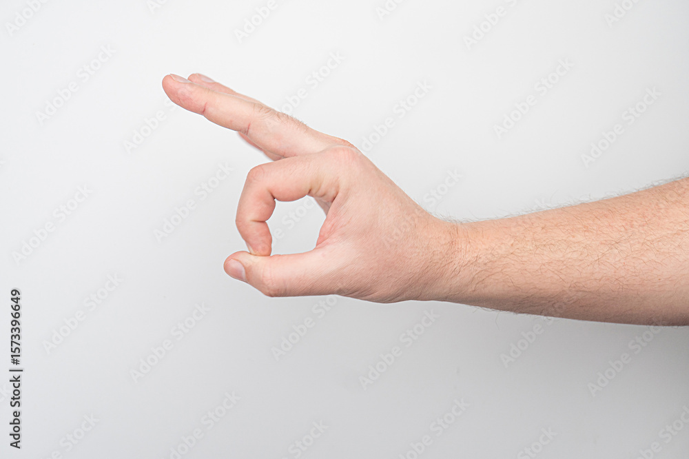 Naklejka premium Close-up of an arm with visible muscle, making a thumbs up gesture against a plain white or off-white background.