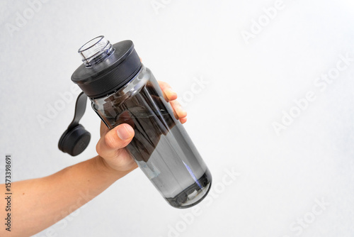 Photograph of a hand holding a water bottle