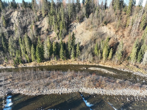 „Panorama Tatr z lotu ptaka” – Zdjęcie ukazuje majestatyczny krajobraz Tatr oświetlonych porannym słońcem. Widać wijącą się rzekę, doliny oraz gęsty las. To malownicza scena, oddająca spokój i piękno 