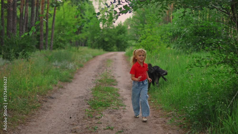 Little girl is running in the forest with her dog who stops for peeing and digging the ground. Slow motion footage of the female Caucasian toddler walking with its lovely black pet in summer woodland.