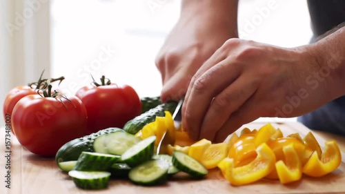 4K food prep clip of hands chopping cucumbers peppers and tomatoes on a kitchen surface Great for cooking videos healthy eating or meal prep content