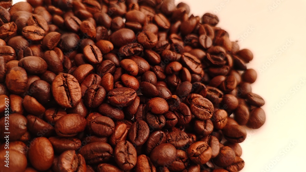 Obraz premium Aromatic Pile CloseUp of Roasted Coffee Beans on Cream Background.