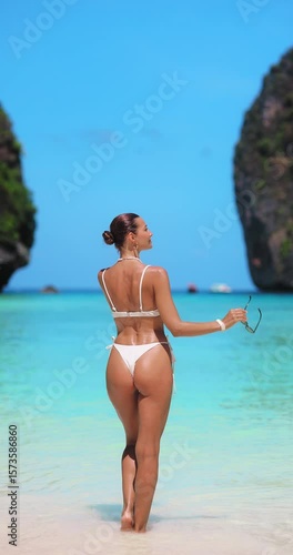 Stylish Woman Holding Sunglasses Walking Into Sea at Maya Bay Beach