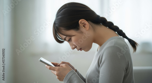 スマホを操作する若い女性　ストレートネック　スマホ首