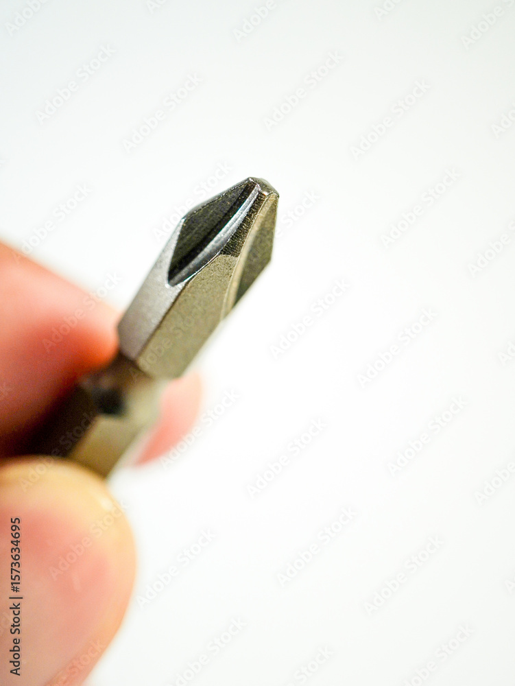 Close up of a metal Phillips head screwdriver bit demonstrates precision engineering for fastening screws and hardware. Close up of a metal Phillips head screwdriver bit demonstrates precision engineering for fastening screws and hardware.
