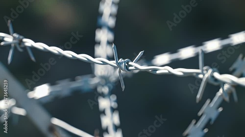 Close-up of twisted metal barbed wire against a blurred outdoor backdrop
