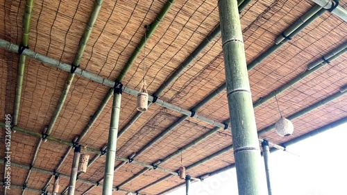 青い竹とすだれでつくられた海の家の天井に吊られ風に揺れる手作りの竹のランタン_30p