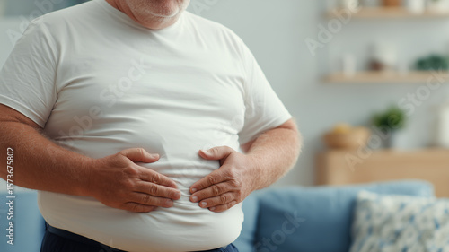 Overweight Man Holding Abdomen Highlighting Obesity Health Risks and Lifestyle Concerns.
