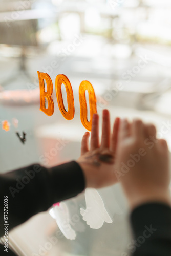 Siblings decorating window with halloween stickers