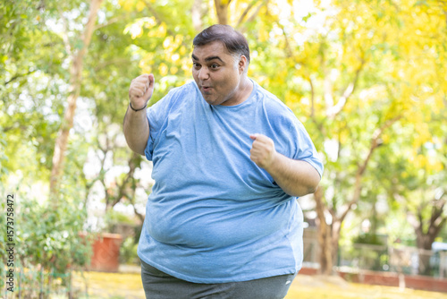 Funny overweight indian man dancing with joy. Crazy fat guy feels excited. Plus size male looking at camera enjoy. Obesity.