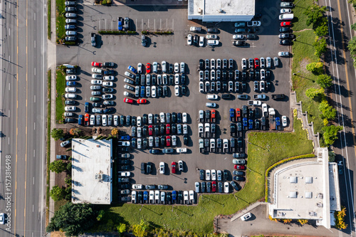 Aerial drone top-down picture of a crowded busy car dealership parking lot in Gladstone, Oregon, with rows of parked vehicles, sedans, pickup trucks and SUVs	