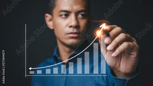 Businessman drawing growth chart with marker, showcasing success and progress. 2026