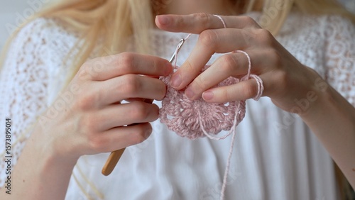 Women's hands crocheting an openwork product. Timeless craft of crochet. 