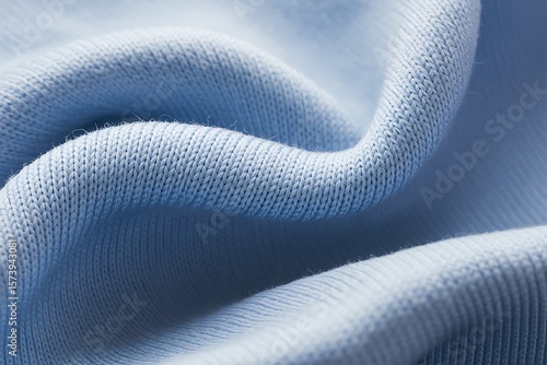 Close up macro shot of soft light blue knitted fabric with gentle folds and texture