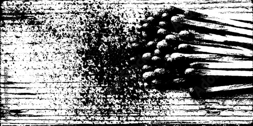 Burnt matchstick bundle with charred tips on grungy wooden surface