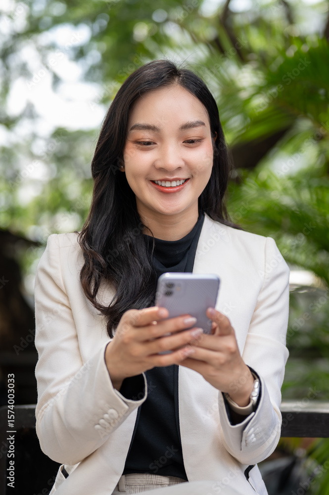 Close up asian female office worker businesswoman holding looking at phone sitting in cafe or garden Close up asian female office worker businesswoman holding looking at phone sitting in cafe or garden