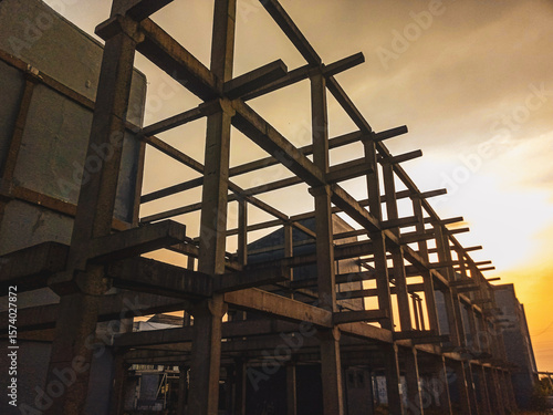 Wallpaper Mural Unfinished two floors construction at housing complex in Sidoarjo with electricity cable hanging on. Silhouette and  sunset view background.
 Torontodigital.ca