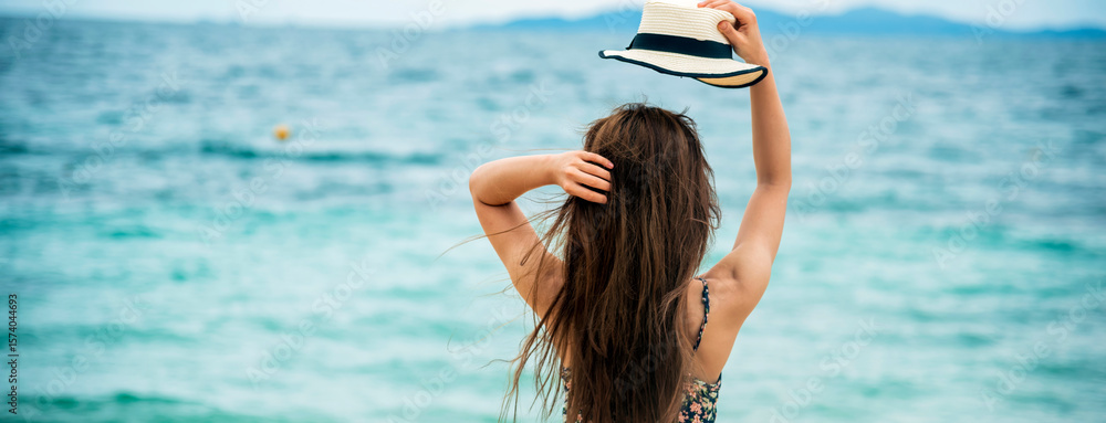 Naklejka premium Banner back side women standing on summer beach wear summer straw hat. Cheerful asian woman barefoot walking on tropical summer beach. Woman walking on beach relax freedom relaxation with copy space