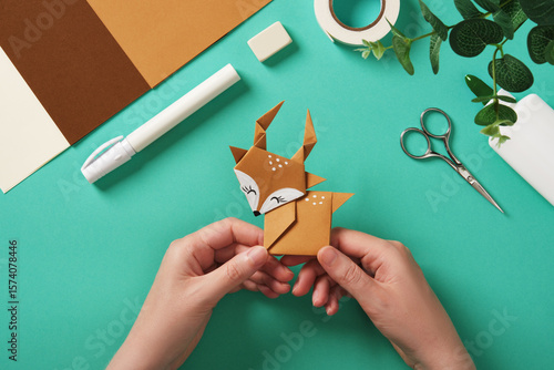Tableau sur toile Hands holding a finished paper deer craft