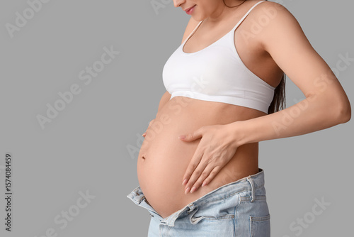 Young pregnant woman on light background, closeup
