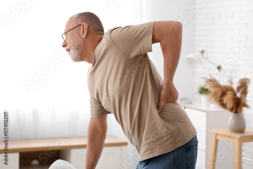 Mature man suffering from back pain at home