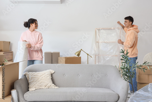 Young couple wrapping shelf...