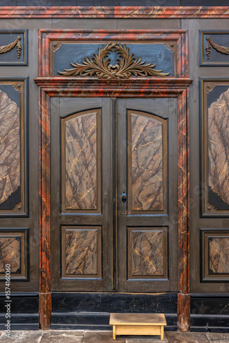 Antique wooden door. Vintage marble texture. Baroque carvings.