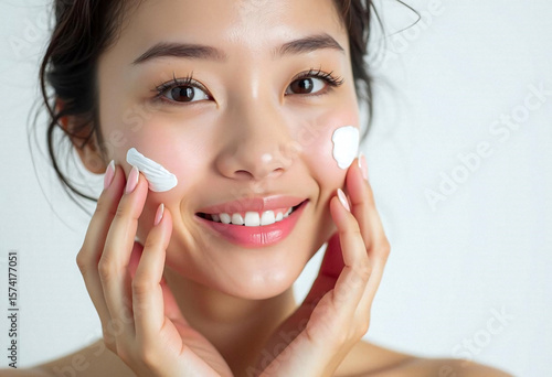 Smiling Asian woman using facial foam