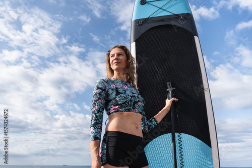 Photography Portrait of woman holding paddle surf board, ready for practicing stand up paddl