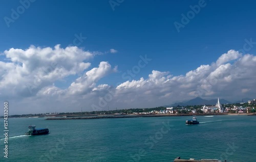A boat and ship travel across scenic coastal waters peacefully