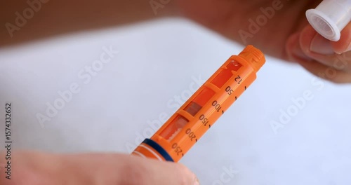 Attaching a Needle to an Orange Insulin Pen on White Background – 4K Slow Motion