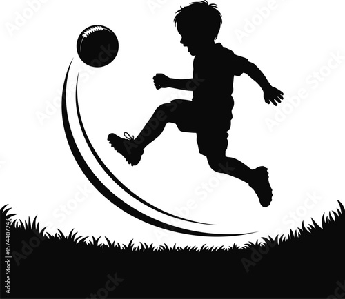 Boy kicking soccer ball in grass playing