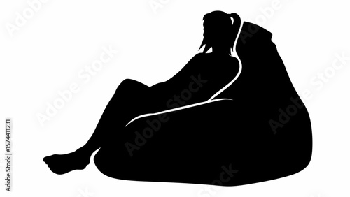 Silhouette of a woman with ponytail reclining on a beanbag chair in a relaxed and comfortable position indoors