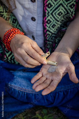 Sao Paulo, SP, Brazil - June 2 2025: Close up of Caucasian woman's hands holding kuripe and snuff for self-administration, medicines from the Amazon rainforest.