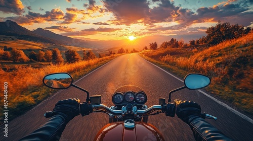 Motorcycle POV driving into a sunset. Mountains in the background and trees on either side of road
