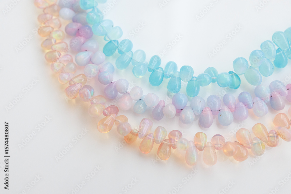 Obraz premium Colorful Opal Beads in Soft Pastel Shades on White Background