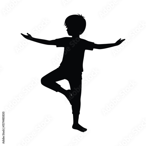 Black silhouette of a young boy balancing on one leg with arms outstretched child