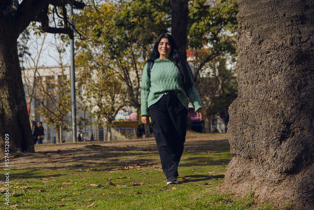 Fototapeta premium happy young woman in the park walking towards the camera.