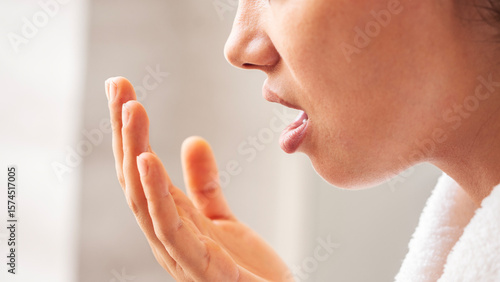 Woman is checking smell of breath	