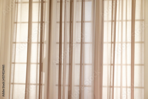 Φωτογραφία Sunlight filtering through sheer curtains in minimalist room interior