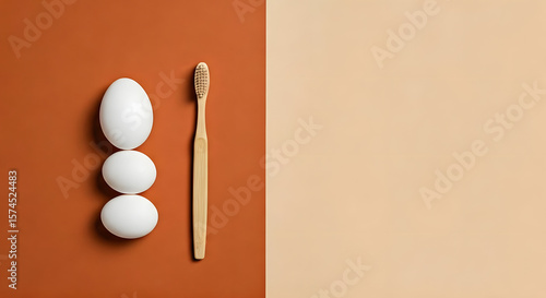 Balanced composition of a white egg and eco toothbrush on a warm terracotta and soft beige background — natural texture, health, and sustainability with copy space on the side