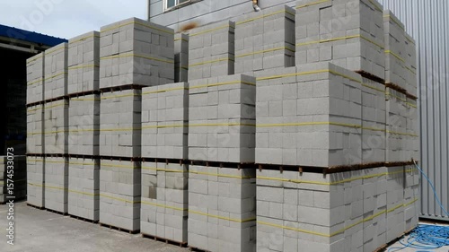 A neat stack of concrete blocks, secured with bright yellow tape, ideal for building and construction projects